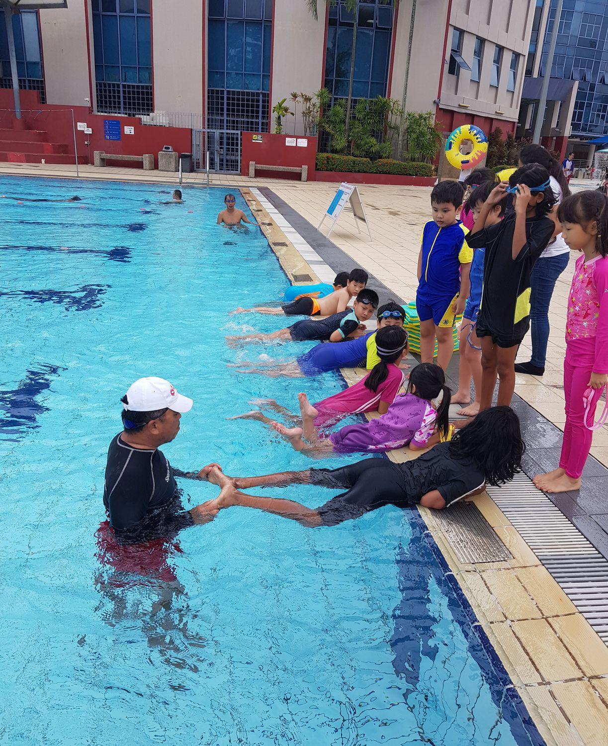 A poolside swimming lesson in progress