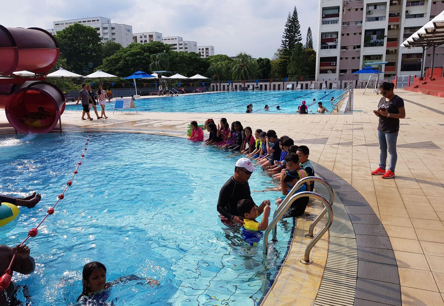 A wide view of a swimming lesson at a public pool