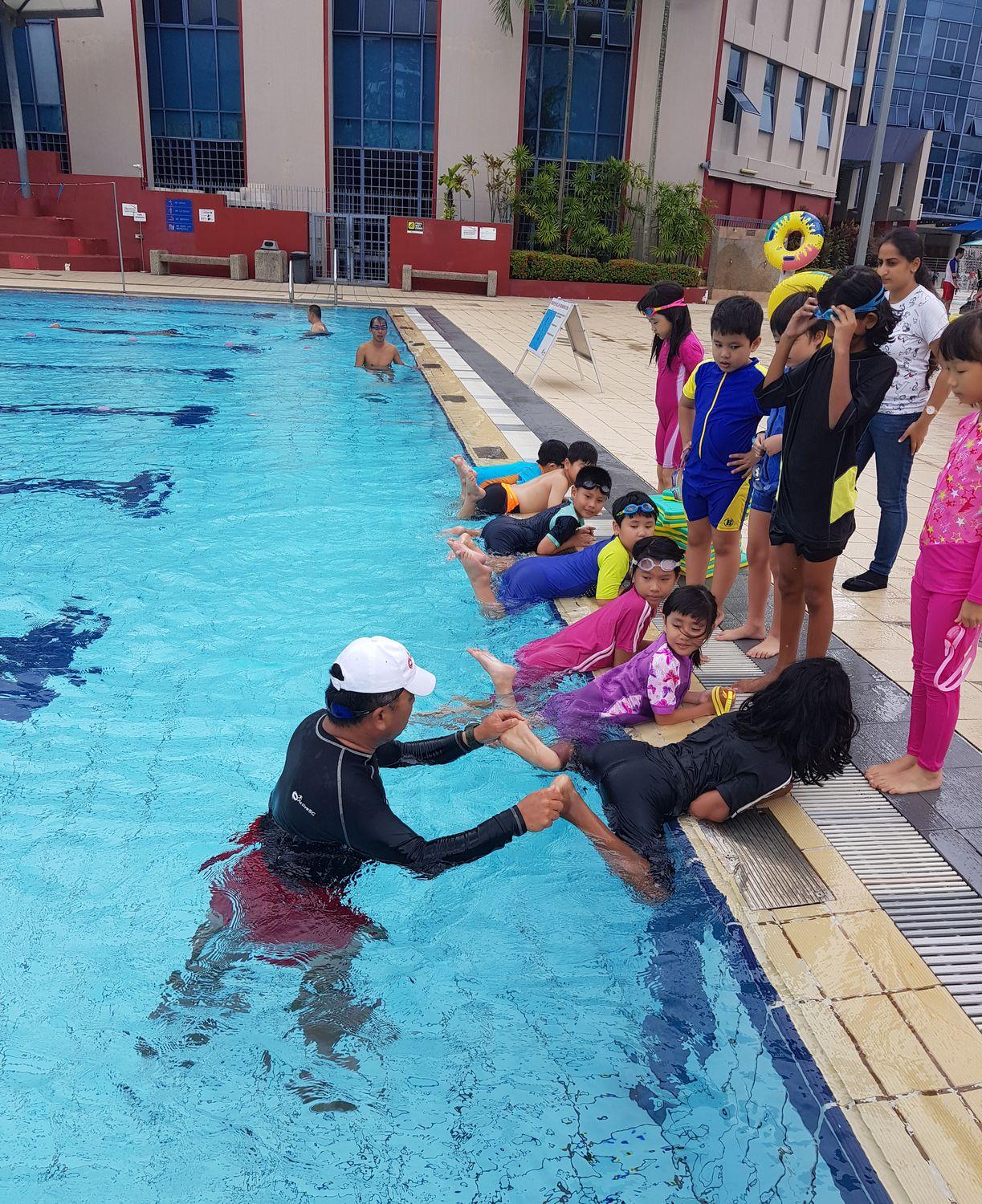 Young swimmers practising at the pool edge