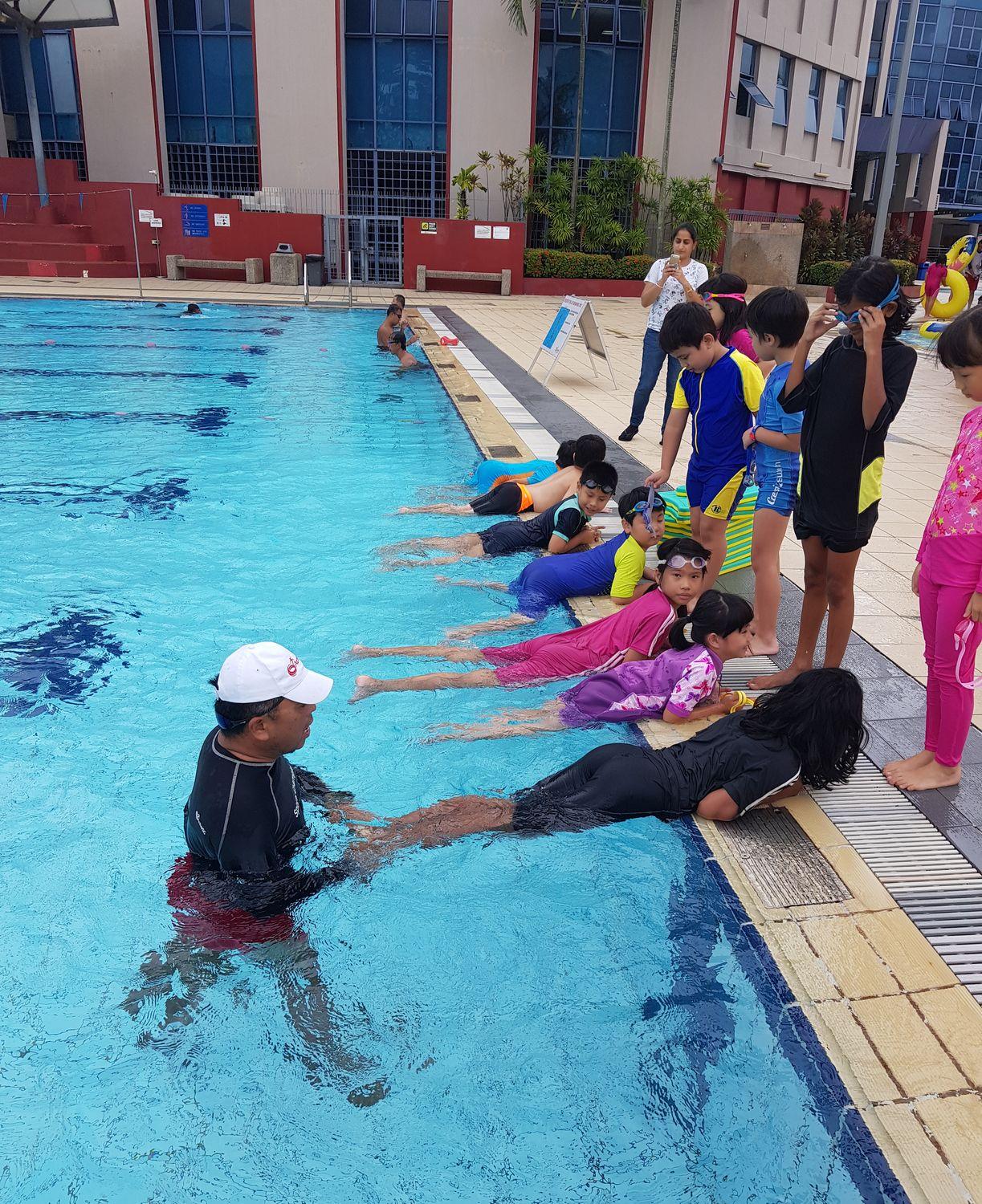 A poolside group swimming lesson