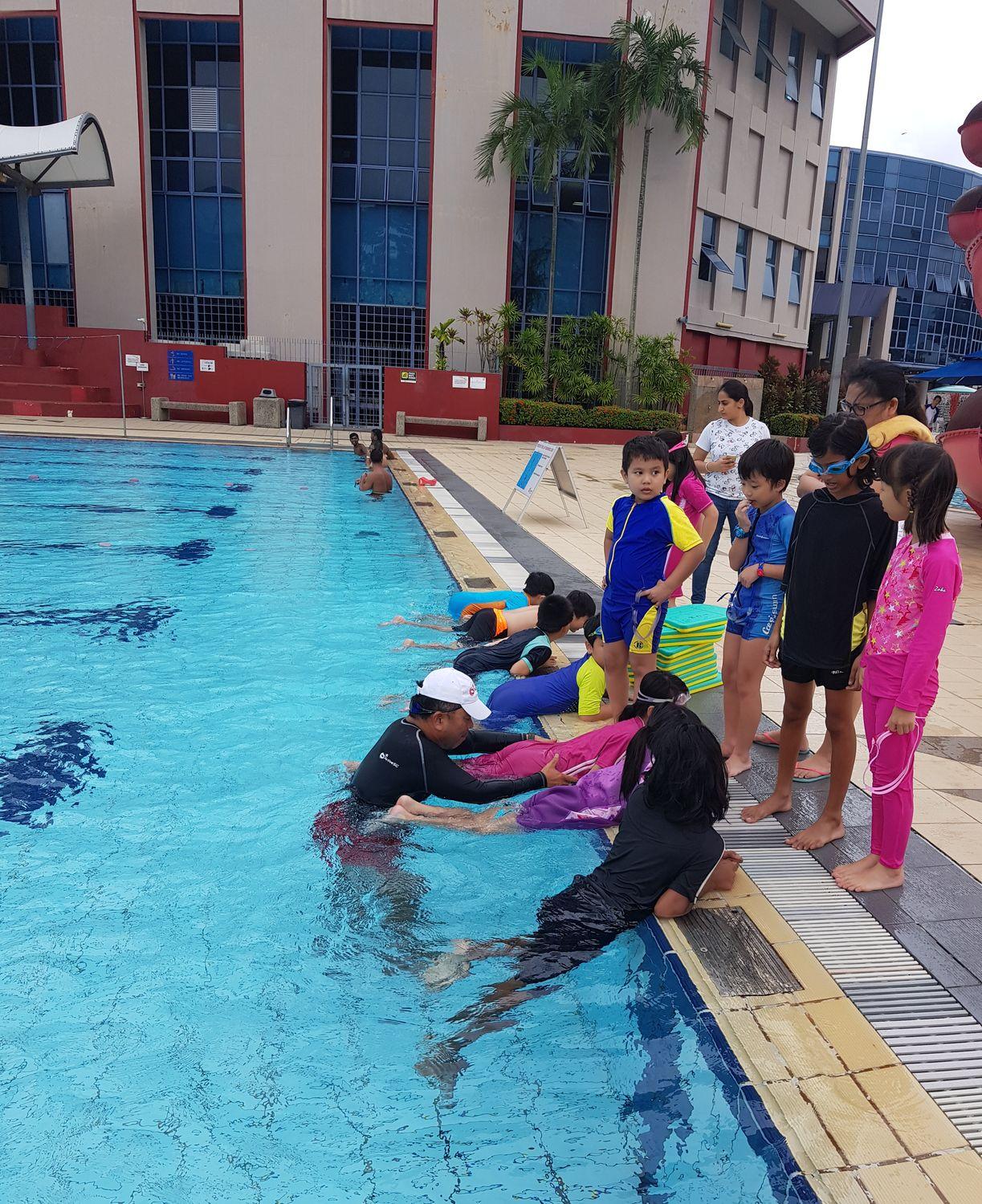 A coach teaching a small group in the water